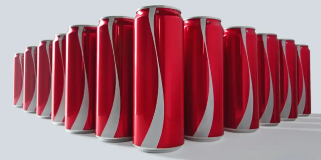 Latas de Coca-Cola alinhadas, destacando a identidade visual icônica da marca.