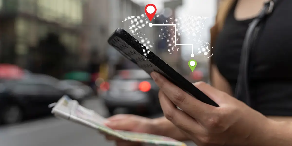 Mulher usando smartphone para verificar mapas com GPS, simbolizando o uso de tecnologia de navegação em viagens.